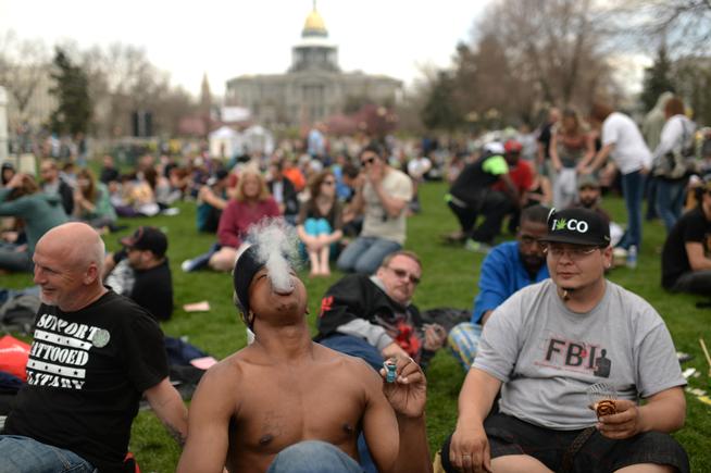 DENVER APRIL 19: Anthony Parker from New York, front, is smoking marijuana during 420 Rally weekend in Civic Center Park. Denver, Colorado. April 19. 2014. (Photo by Hyoung Chang/The Denver Post)